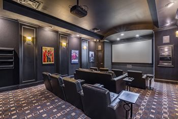 A dark room with a screen and chairs.